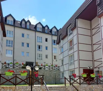 a row of buildings with flowerpots in front of them at Čar30 Kraljevi čardaci in Kopaonik