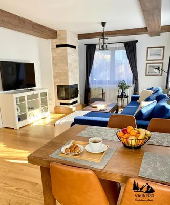 a living room with a table and a blue couch at Duplex Vidik B30 - 85m2 in Kopaonik