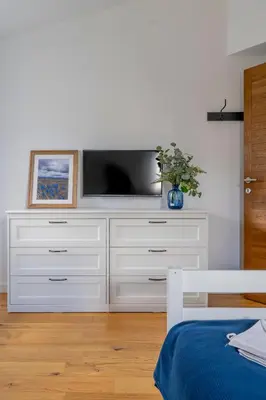 a white dresser with a television on top of it at Duplex Vidik B30 - 85m2 in Kopaonik