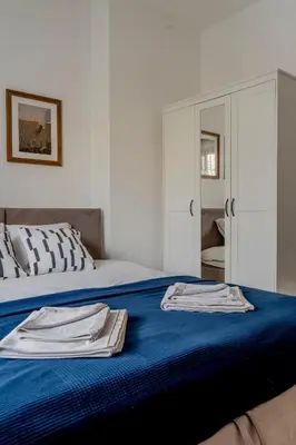 a bedroom with a bed with blue sheets and a mirror at Duplex Vidik B30 - 85m2 in Kopaonik