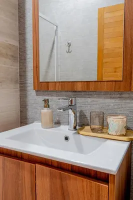a white sink in a bathroom with a mirror at Duplex Vidik B30 - 85m2 in Kopaonik