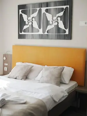 a bed with white pillows and a picture on the wall at DeltaLux apartmani Milmari Kopaonik in Kopaonik