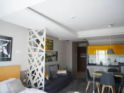 a living room with a blue couch and a kitchen at DeltaLux apartmani Milmari Kopaonik in Kopaonik