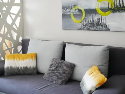 a couch with pillows on it in a living room at DeltaLux apartmani Milmari Kopaonik in Kopaonik