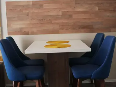 a table with four blue chairs and a white table at DeltaLux apartmani Milmari Kopaonik in Kopaonik