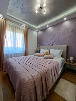 a bedroom with a large bed with a teddy bear on it at Apartman Hedonist in Vrnjačka Banja