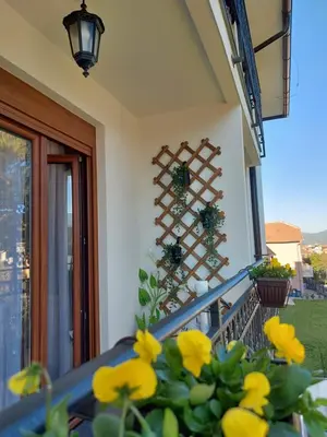 a house with yellow flowers on a balcony at Apartman Hedonist in Vrnjačka Banja