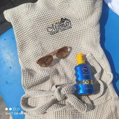 a pair of sunglasses and a bottle of sunscreen at L&N Apartmani Kopaonik-Milmari Resort in Kopaonik