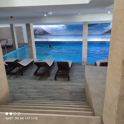 a room with a painting of the ocean on the wall at L&N Apartmani Kopaonik-Milmari Resort in Kopaonik