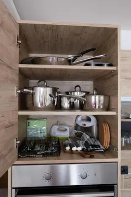 a kitchen with many pots and pans on shelves at L&N Apartmani Kopaonik-Milmari Resort in Kopaonik
