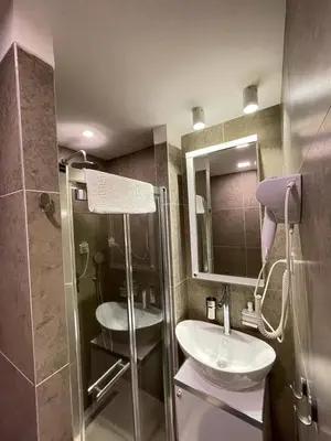 a bathroom with a shower and a sink and a mirror at Planinski vrhovi Jelač in Kopaonik