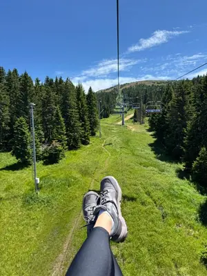 a person with their feet up on a ski lift at Planinski vrhovi Jelač in Kopaonik