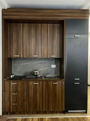 a kitchen with wooden cabinets and a sink and a refrigerator at Apartman Milosavljevic-President Kop in Kopaonik
