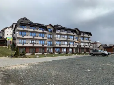 a large building with a car parked in front of it at Milmari Premier40 in Kopaonik