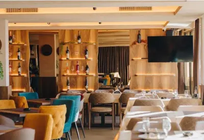 a restaurant with tables and chairs and a flat screen tv at VitaDea Milmari Kopaonik in Kopaonik