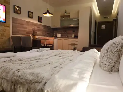 a large white bed in a room with a kitchen at Milmari Premier05 in Kopaonik