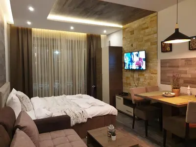 a living room with a bed and a dining room at Milmari Premier05 in Kopaonik