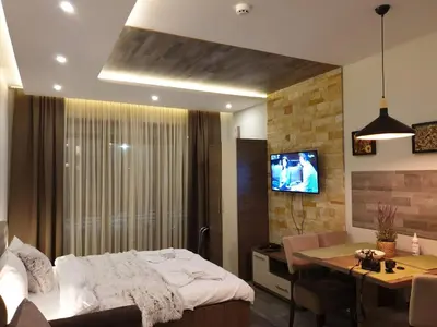 a bedroom with a bed and a table and a television at Milmari Premier05 in Kopaonik