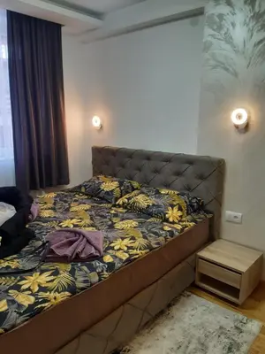 a bedroom with a large bed with a yellow and blue blanket at apartman Kraljevi čardaci Sadikovic sa garažom in Kopaonik