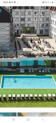 a large swimming pool in front of a large building at apartman Kraljevi čardaci Sadikovic sa garažom in Kopaonik