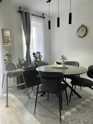 a dining room with a table and chairs and a clock at Vila Vedrana Apartman Nedeljkovic in Brzeće