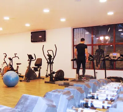 a man standing in a gym with exercise equipment at Apartman Kraljevi cardaci 5b-32 in Kopaonik