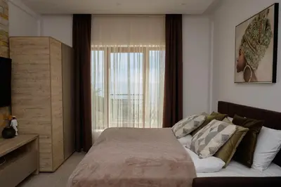 a bedroom with a bed and a large window at Ski & Spa Apartment N34 Milmari Resort Kopaonik in Kopaonik