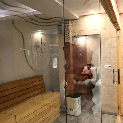 a man sitting on a bench in a room at Ski & Spa Apartment N34 Milmari Resort Kopaonik in Kopaonik