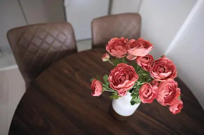 a vase filled with red roses sitting on a table at Ski & Spa Apartment N34 Milmari Resort Kopaonik in Kopaonik