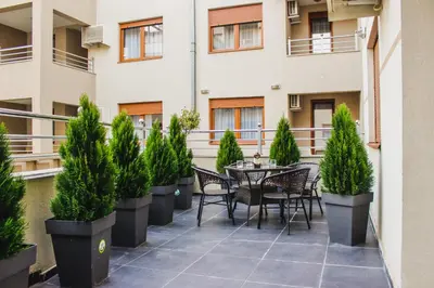 a patio with a table and chairs and potted plants at Apartman DreamHome in Vrnjačka Banja