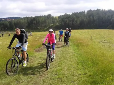 a group of people riding bikes in a field at Apartman Draškovic - Goč in Biserske Kuće
