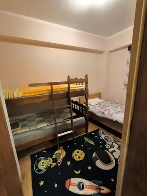a small bedroom with two bunk beds and a rug at Apartman Djole in Brzeće
