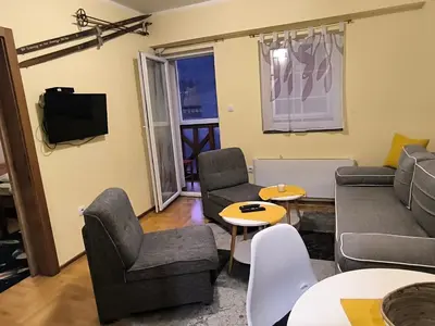 a living room with a couch and chairs and a tv at Apartman Djole in Brzeće