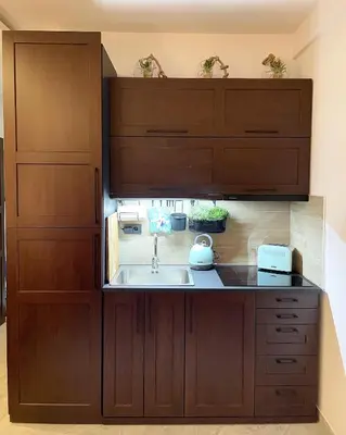 a kitchen with wooden cabinets and a sink at Apartmani Madera in Kopaonik