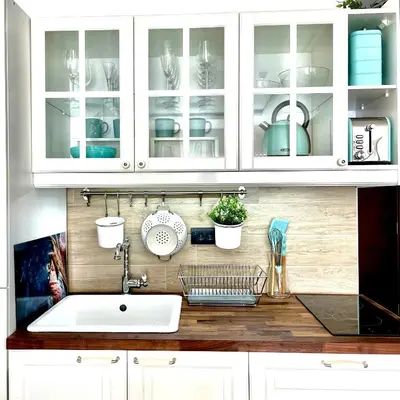 a kitchen counter with white cabinets and a sink at Apartmani Madera in Kopaonik