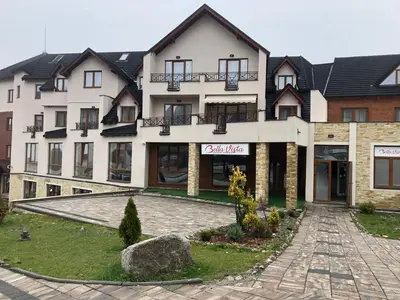 a large white building with a sign on it at Apartmani Madera in Kopaonik