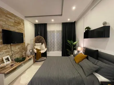 a bedroom with a large bed and a couch at Apartmani Madera in Kopaonik