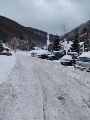 a snow covered road with cars parked in a parking lot at Bele staze 59 in Brus