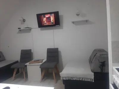 a room with two chairs and a tv on a wall at Bele staze 59 in Brus
