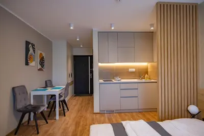 a room with a bed and a kitchen and a desk at Omega Apartments in Vrnjačka Banja