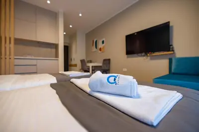 a hotel room with two beds with towels at Omega Apartments in Vrnjačka Banja