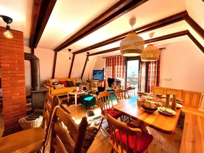 a dining room and living room with a wooden table at Kuća na Kopaoniku - Rani mraz in Kopaonik