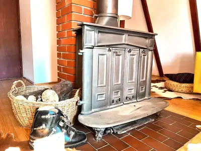 a wood stove sitting in a room with a basket at Kuća na Kopaoniku - Rani mraz in Kopaonik