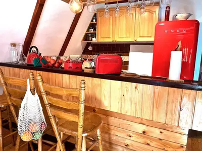 a kitchen with a counter with two chairs and a red refrigerator at Kuća na Kopaoniku - Rani mraz in Kopaonik