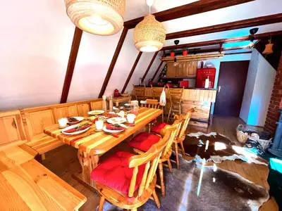 a dining room with a wooden table and chairs at Kuća na Kopaoniku - Rani mraz in Kopaonik