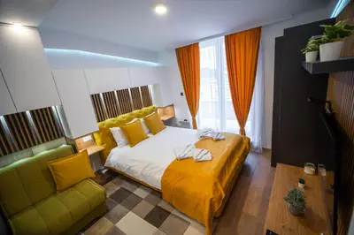 a bedroom with a large bed and a green couch at Pleasure Lux MILMARI-Kopaonik in Kopaonik