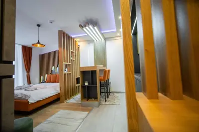 a small bedroom with a bed and a room with a mirror at Pleasure Lux MILMARI-Kopaonik in Kopaonik