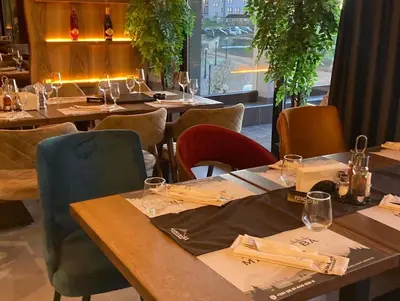 a dining room with tables and chairs and a window at Pleasure Lux MILMARI-Kopaonik in Kopaonik