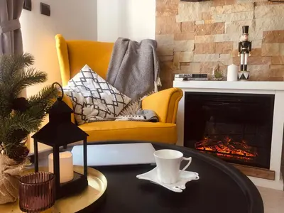 a living room with a coffee table in front of a fireplace at Kopaonik Milmari Apartment N95 in Kopaonik
