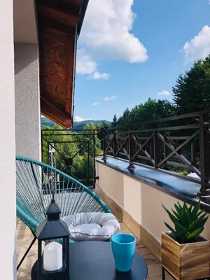 a balcony with a table and a chair on a balcony at Kopaonik Milmari Apartment N95 in Kopaonik